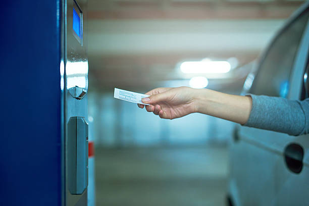 Just out of reach Shot of an unrecognizable driver inserting a ticket into a parking meter entry fees stock pictures, royalty-free photos & images